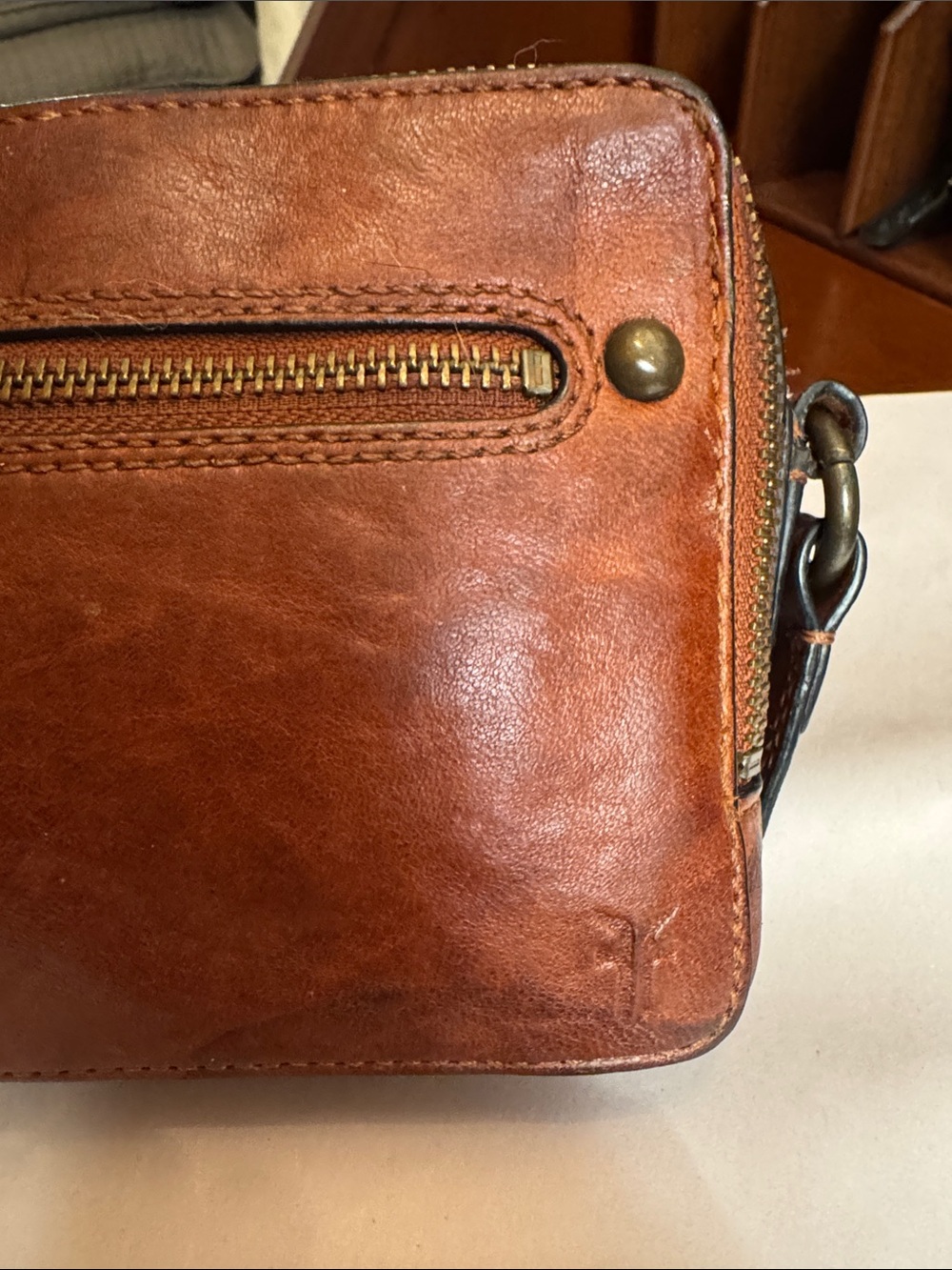Frye crossbody 9x5x3” wide.  Two zippered entrances on top and one on side.